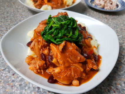Bits of Pig Casserole  I intentionally bought the least promising bits of Pork. Two Trotters and a Shank. When I was in the Butchers the Shanks were put in boiling bags in the Ham Boiler overnight and sold on the hot counter, but the ‘Running Gear’ as Geoffrey called them invariably went in the Bone & Fat bin outside. This was emptied every couple of weeks and taken away for rendering.  So can you make anything good from these scraggly bits of meat in the slow cooker? Oh yes you can!  Ingredients for the Casserole:-  2 Pigs Trotters 1 Pork Shank 1 Large Onion, roughly sliced 1 Tin of  Kidney Beans     1 Tin of White Beans, whatever you have 1 Tin of Chopped Tomatoes ½ a Tube of Tomato Puree 1 Stock Cube / Stock Pot Salt & Pepper to season 1 Tsp of Chilli Flakes Cider, as cheap as you can get. 1 Tsp of Marmite (We use the Morrisons own brand as it is Gluten free)   Method:-  (1) Bung everything in the Slow Cooker on high. (2) Add enough Cider to cover everything. (3) After 4 hours push the meat down if it has floated to the top and give everything a good stir. (4) After another 4 hours remove the meat. (5) With a fort and reasonably sharp knife strip the meat from the bones and skin (These were a real threat for our Foxes). (6) Return the meat to the slow cooker and stir well.  We served this over Garlic Mashed Potatoes and garnished it with sautéed Spinach. This would easily have fed a family of 4 and was actually really tasty. 